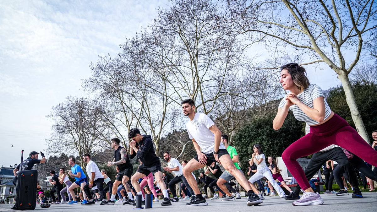 A lively outdoor fitness class in İstanbul with diverse participants engaged in exercise routines.